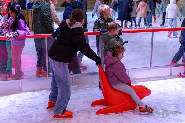 Kind op een schaatshulp op de ijsbaan